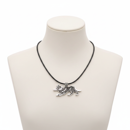 A detailed antique silver wolf pendant with Nordic engravings on a black leather cord, displayed on a minimalist white mannequin.