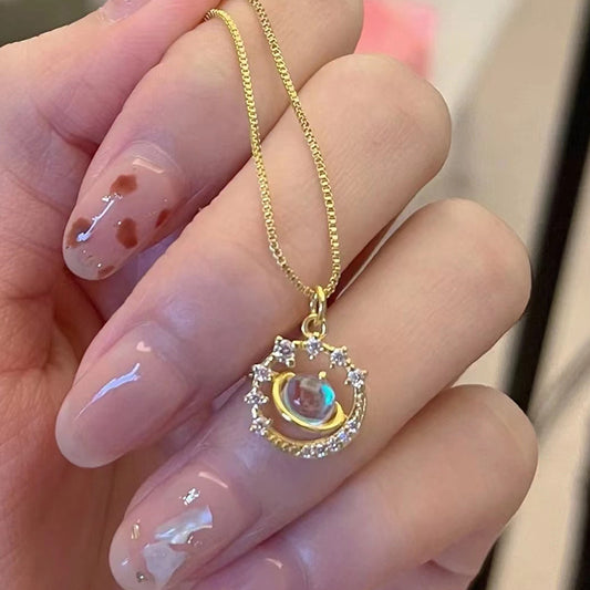 Gold planet pendant necklace with a glowing center stone and crystal zirconia halo, celestial galaxy-themed boutique jewelry.