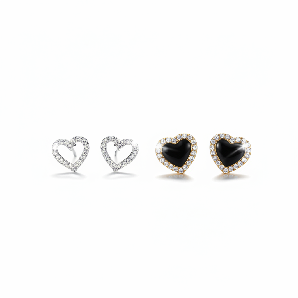 A high-resolution product shot featuring two pairs of heart-shaped stud earrings; one pair is silver with an open-heart design encrusted in sparkling crystals, and the other is gold-toned with a solid black onyx-style center surrounded by a crystal halo, both displayed against a pure white background.