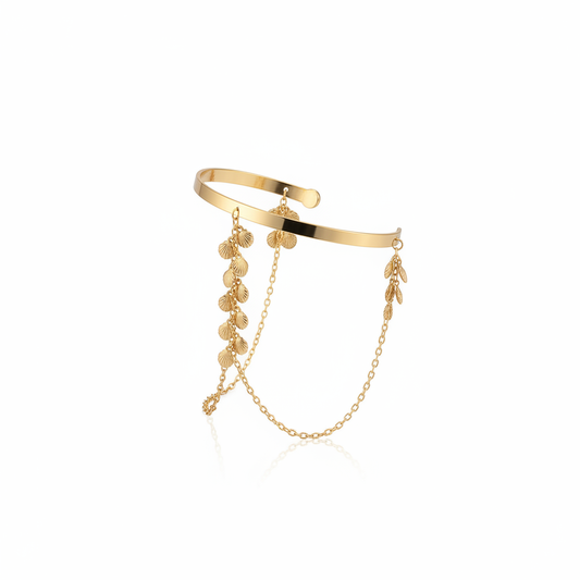 Gold layered cuff bracelet with chain and leaf charms on a white background
