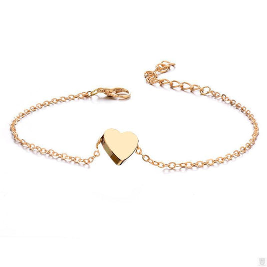 Minimalist gold-tone link chain bracelet featuring a solid polished heart charm, centered on a white background with an adjustable lobster clasp.