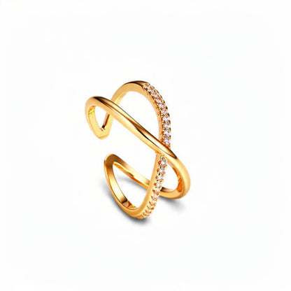 Modern gold crisscross X ring on pure white background, open adjustable band with crystal pave accent on one side, minimalist statement jewelry