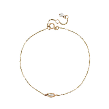 Fine gold-tone cable chain bracelet featuring a horizontal oval-set pearl charm and a small pearl dangle on the adjustable clasp, isolated on a white background.
