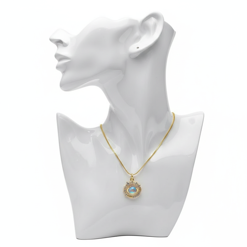 A gold-toned necklace featuring a circular pendant with an iridescent blue opal "evil eye" center. The eye is surrounded by a celestial-inspired halo of clear crystals and small gold beads. The necklace is displayed on a white mannequin bust against a plain white background.