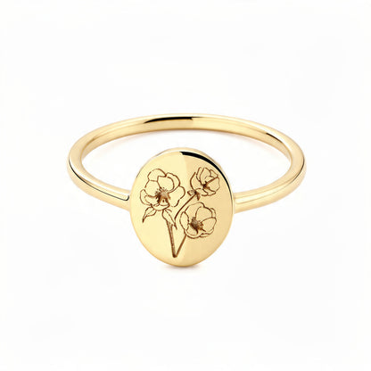 Delicate gold signet ring on pure white background with engraved botanical flower bouquet on oval disc, thin polished band, minimalist floral jewelry

