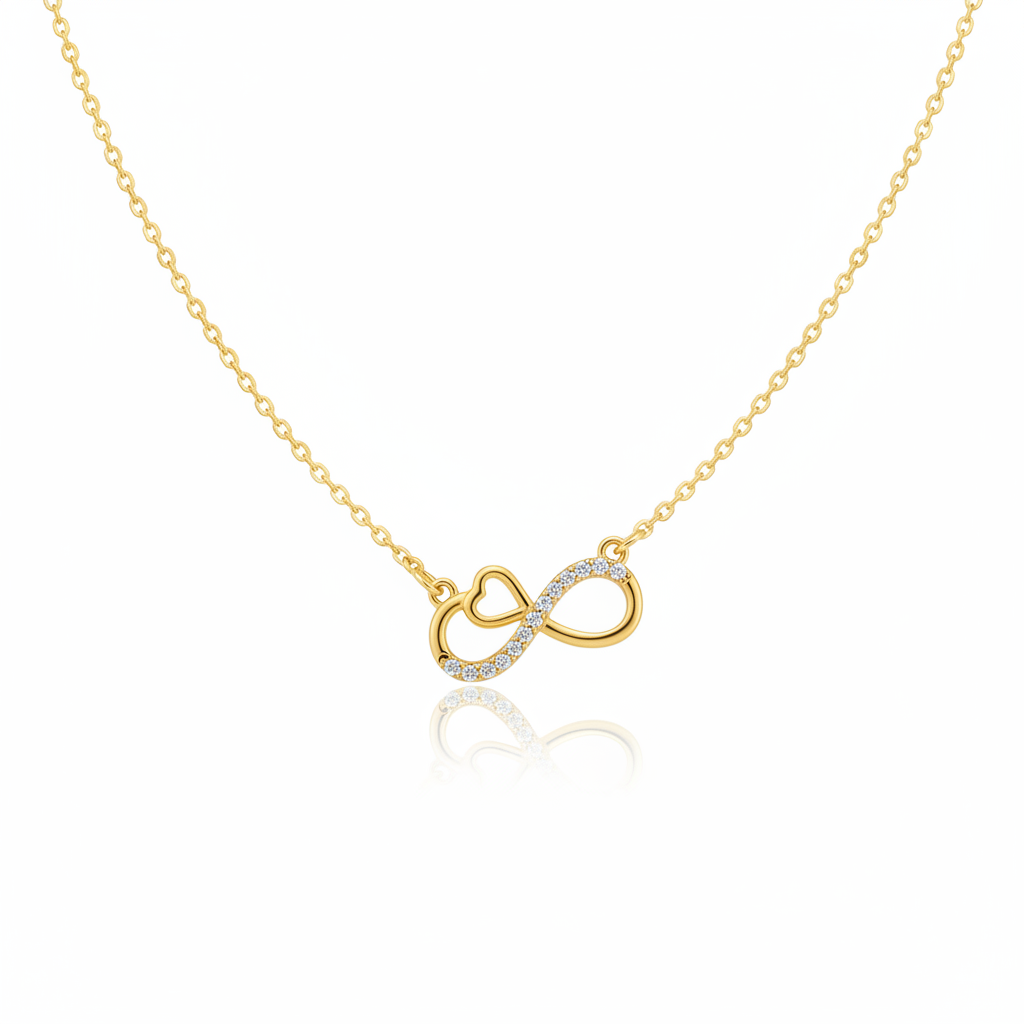 A gold-toned necklace featuring an infinity symbol pendant with an integrated heart detail. One side of the infinity loop is pavé-set with shimmering clear crystals. The pendant is attached to a fine gold cable chain and shown against a white background with a subtle reflection.