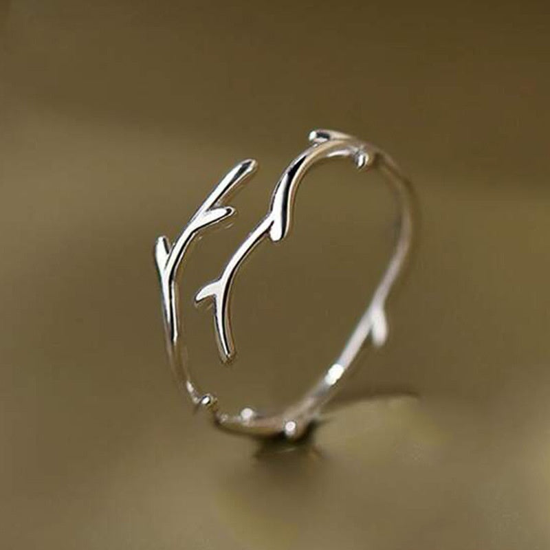 Silver branch-like bracelet on a beige background