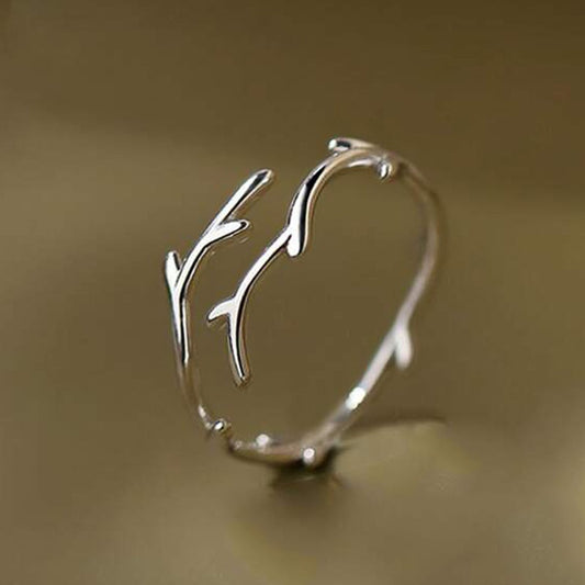 Silver branch-like bracelet on a beige background