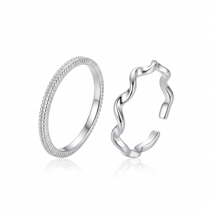 "Minimalist silver ring set featuring one textured beaded band and one adjustable wavy ripple band on a white background."