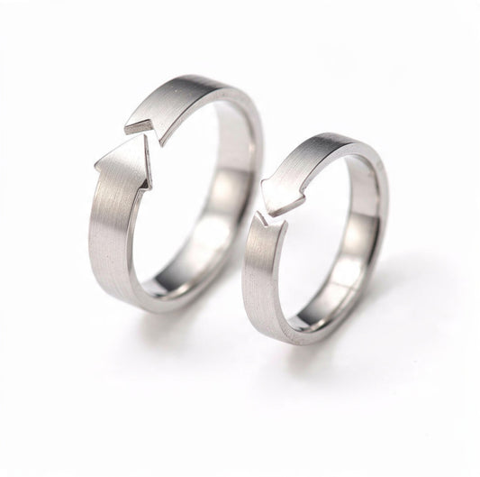 A set of two brushed sterling silver adjustable rings featuring arrow cutout designs, one in a larger size and one smaller, displayed side by side on a pure white background.