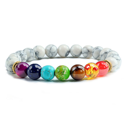 Stacked set of 4 matte black bracelets featuring a lotus flower, feather charm, and heart detail on a wrist.