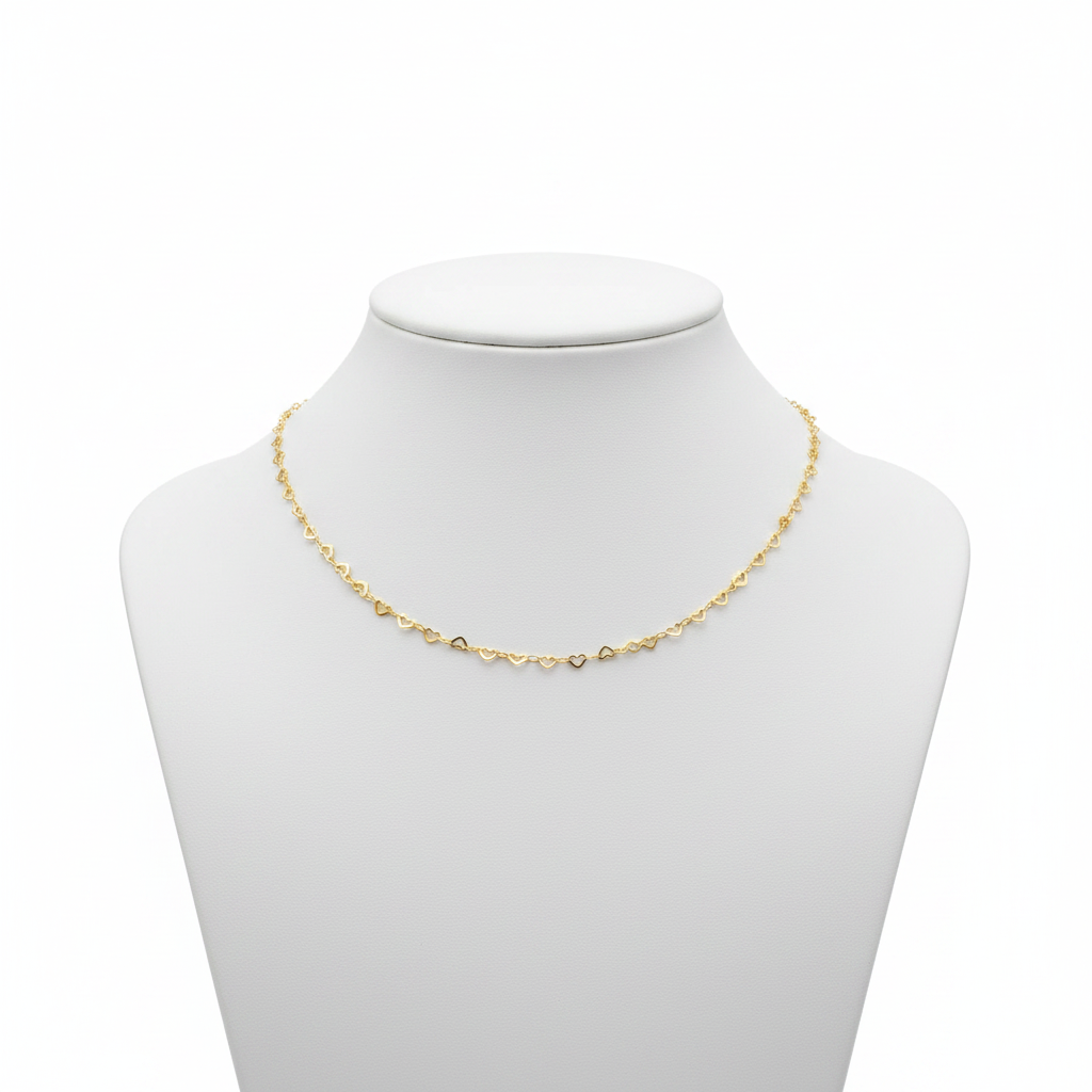 Dainty 18k gold-plated necklace featuring a continuous chain of small interlocking open-heart links, styled on a model wearing a white linen shirt.