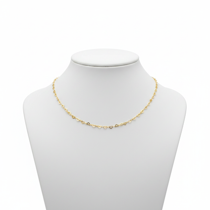 Dainty 18k gold-plated necklace featuring a continuous chain of small interlocking open-heart links, styled on a model wearing a white linen shirt.
