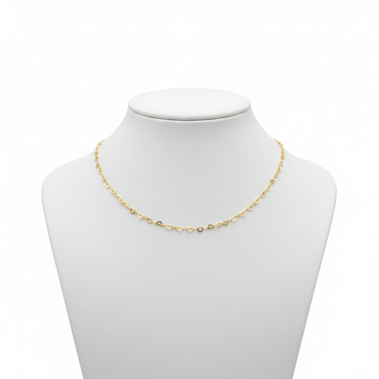 Dainty 18k gold-plated necklace featuring a continuous chain of small interlocking open-heart links, styled on a model wearing a white linen shirt.