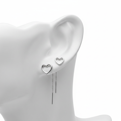 A high-resolution, close-up shot of silver open-heart stud earrings and long threader earrings with sleek bar drops, displayed on a white mannequin ear against a pure white background.