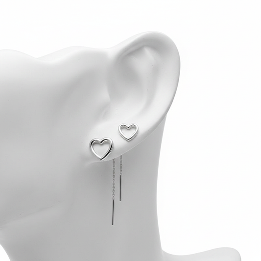 A high-resolution, close-up shot of silver open-heart stud earrings and long threader earrings with sleek bar drops, displayed on a white mannequin ear against a pure white background.