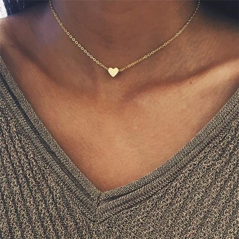 Dainty gold heart pendant necklace on a thin cross chain, minimalist jewelry for women, modern office fashion style