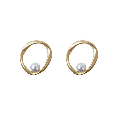 Pair of irregular wavy gold hoop earrings featuring a single white pearl accent in a minimalist organic design.