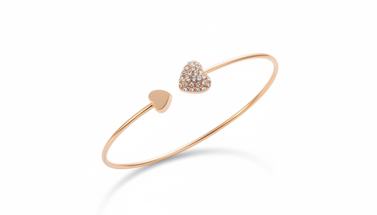 Open-ended rose gold heart bangle featuring one polished gold heart and one heart encrusted with shimmering pave crystals.