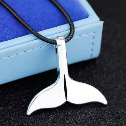 Polished silver shark tail pendant on a black leather rope chain, nautical ocean-inspired necklace for unisex fashion.