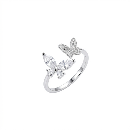A silver adjustable open ring featuring two butterflies, one set with marquise-cut crystals and the other with small pavé stones, shown on a pure white background.