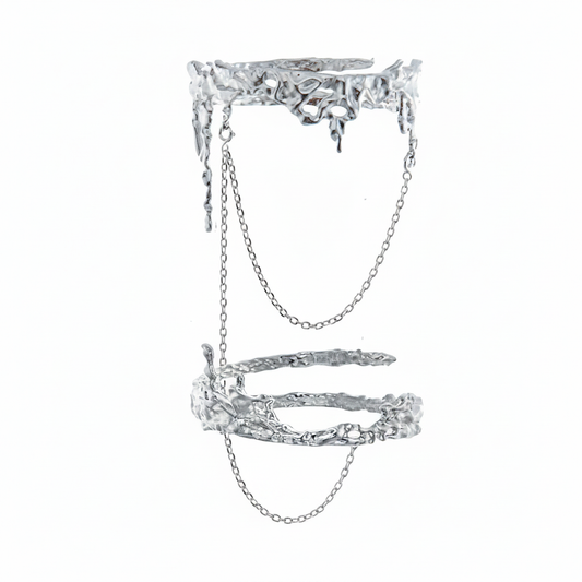 An avant-garde silver-toned double finger ring featuring a molten liquid-metal texture and delicate connecting chains, isolated on a white background.