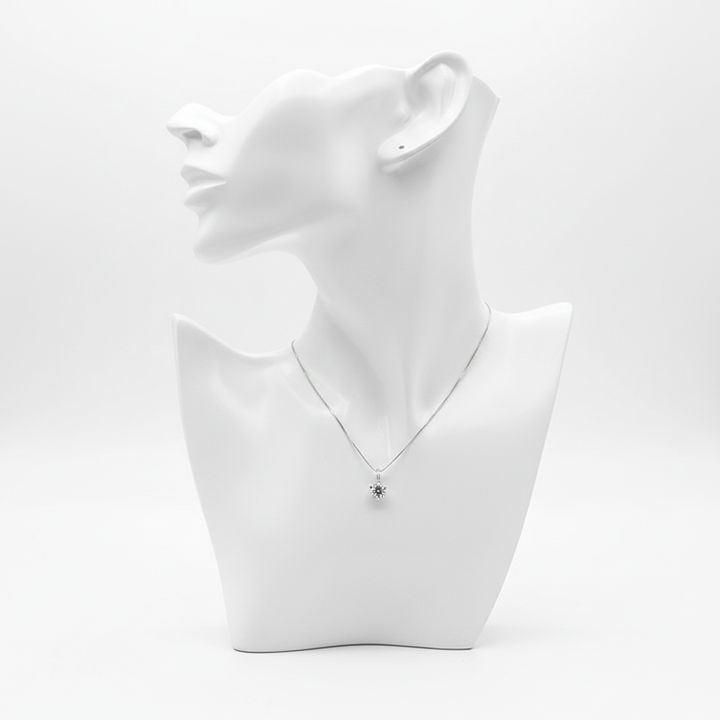 A delicate silver-toned necklace featuring a small sunflower-shaped pendant with a dark center, displayed on a minimalist white mannequin bust.