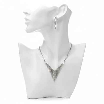 A shimmering silver-toned jewelry set featuring a tapered V-shaped mesh necklace and matching linear drop earrings on a white minimalist bust.