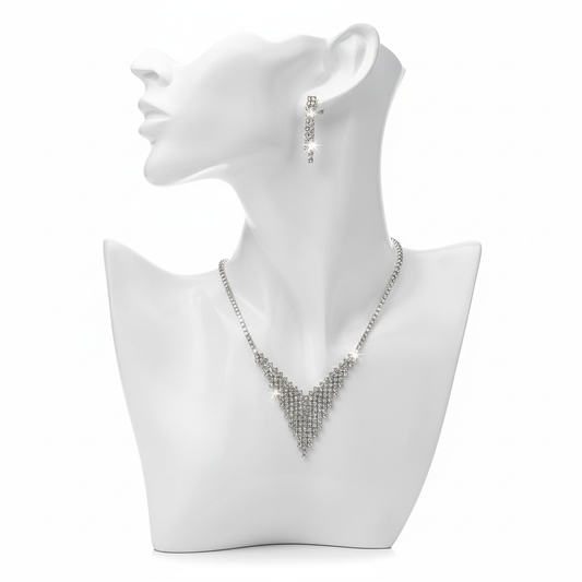 A shimmering silver-toned jewelry set featuring a tapered V-shaped mesh necklace and matching linear drop earrings on a white minimalist bust.