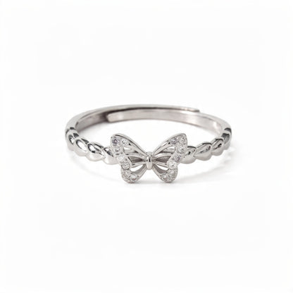A polished sterling silver adjustable ring featuring a crystal-pavé butterfly centerpiece with a twisted band, centered on a pure white background.