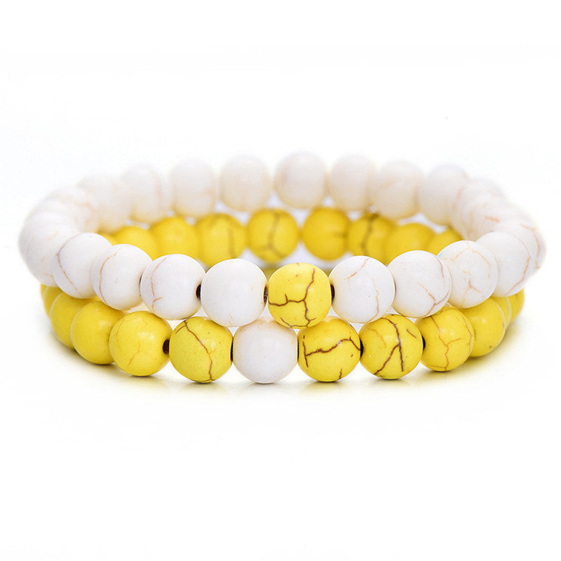 Set of two stretch bracelets featuring marbled white howlite and vibrant yellow stone beads on a white background.