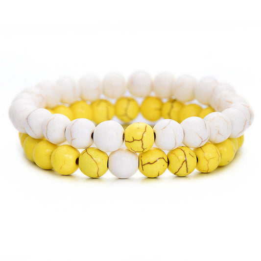 Set of two stretch bracelets featuring marbled white howlite and vibrant yellow stone beads on a white background.