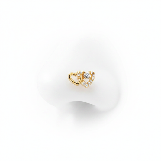 A luxury 18k gold-dipped nose stud featuring two interlocking hearts—one in polished gold and the other pavé-set with brilliant crystals—crafted from tarnish-resistant titanium steel for a minimalist editorial look.