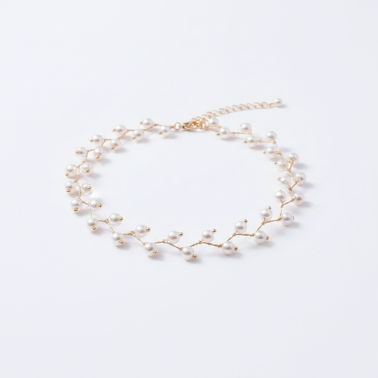 A delicate 18k gold-dipped choker featuring a branch-inspired silhouette adorned with small, radiant pearls, designed with a tarnish-resistant titanium steel base for a modern, high-end editorial aesthetic.