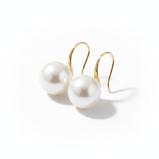 Minimalist 18k gold-dipped hook earrings featuring large, high-lustre white pearls, designed with a tarnish-resistant titanium steel base for a clean, modern editorial look.