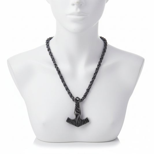 An antique silver-finished Mjolnir pendant on a thick braided wheat chain displayed on a white minimalist mannequin bust.