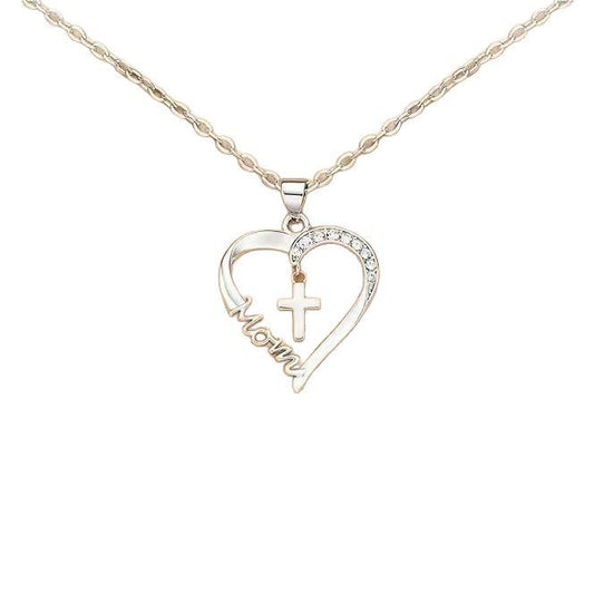 A two-tone heart pendant necklace on a rose gold chain. The open heart pendant features a silver-toned side pavé-set with clear crystals and a rose gold-toned side with the word "Mom" engraved in a flowing script. A small silver-toned cross hangs within the center of the heart. The jewelry is shown against a plain white background.