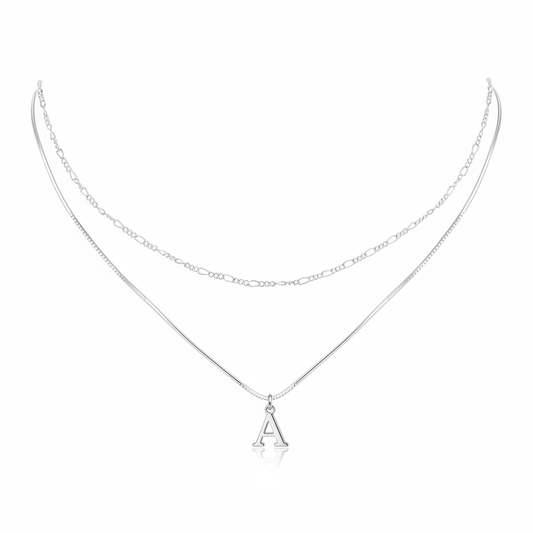 Minimalist silver layered necklace featuring a sleek snake chain with an initial A pendant and a delicate figaro link chain